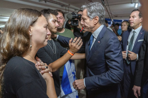 US Secretary of State Antony Blinken is embraced by Lior Gelbaum, left, 24, a dual US-Israeli citizen, and her boyfriend Klil Valiano.